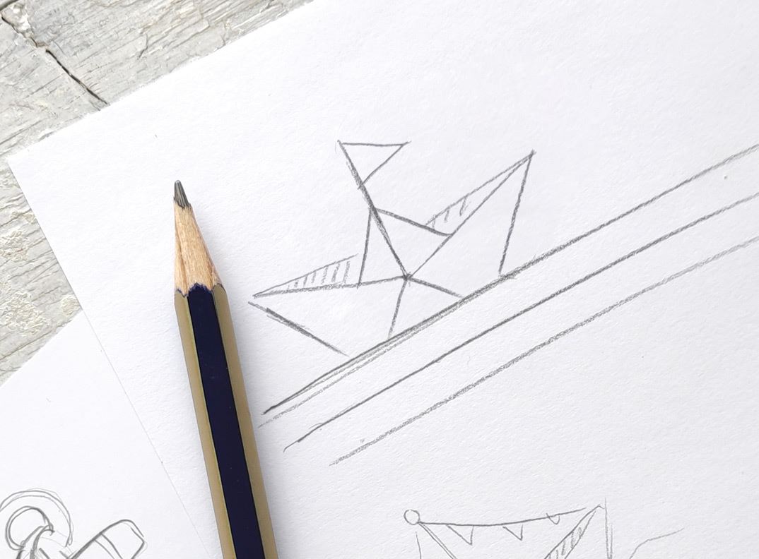 A drawn paper boat next to a pencil.